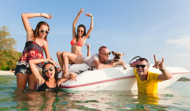 Junge Leute mit Hund auf Boot und im Wasser in Thailand